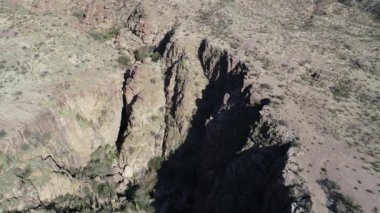 Kuru, çöl kırmızısı, manzara, derin kayalıkların detay kanyon üzerinde uçan hava drone sahne. Rioja Eyaleti Arjantin Hualco kanyon. Yerli monte bitki örtüsü