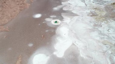 Mavi lagüne doğru beyaz salar boyunca uçan hava drone sahnesi, deniz gözleri, doğal çizimler. Arizaro salar'da Ojos de mar. Tolar grande, Salta, Arjantin