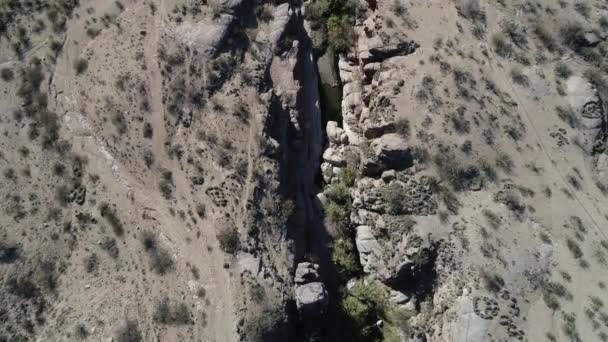 Scène de drone senital aérien volant le long d'une rivière à l'intérieur d'un petit canyon rocheux dans un paysage désertique sec. Canyon Hualco dans la province de Rioja, Argentine 