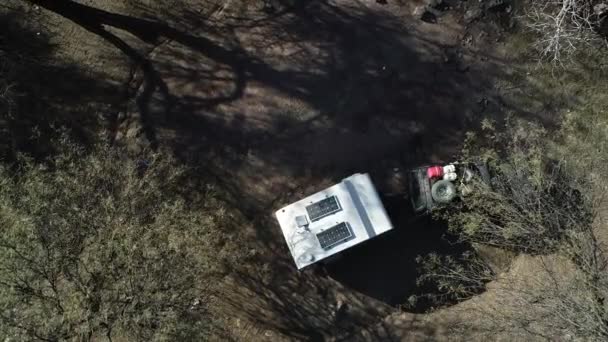 Escena aérea de drones senitales volando sobre árboles mostrando detalles de caravana, autocaravana, preparada para vivir en la naturaleza, experiencia de aventura. Provincia de Rioja, Argentina — Vídeos de Stock