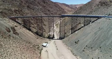 Terki dağlık arazide eski metal köprüden geçerken trenin üzerinden hava uçuşu. Couds Treni, tren de las nubes, San Antonio de los Cobres, Salta, Arjantin.