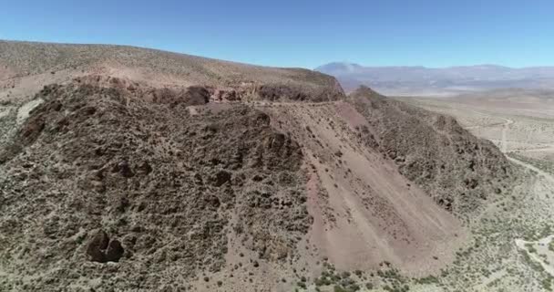 Aerial drone scene approaching train rail that crosses desertic mountain. Train of the clouds, tren de las nubes, San Antonio de los Cobres, Salta, Argentina. Touristic and recreational ride. — Stock Video