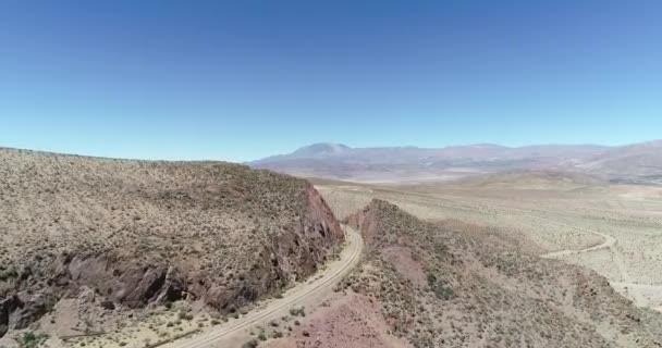 砂漠の山を横切る列車のレールに近づく空中ドローンシーン。雲の列車、トレン・デ・ラス・ヌーブ、サンアントニオ・デ・ロス・コブレス、サルタ、アルゼンチン。観光とレクリエーションの乗り物. — ストック動画