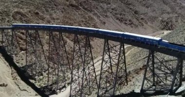 Çölgibi dağlık arazide eski metal köprüden geçerken trene binmek için önden senital görüşe doğru giden havadan. Couds Treni, tren de las nubes, San Antonio de los Cobres