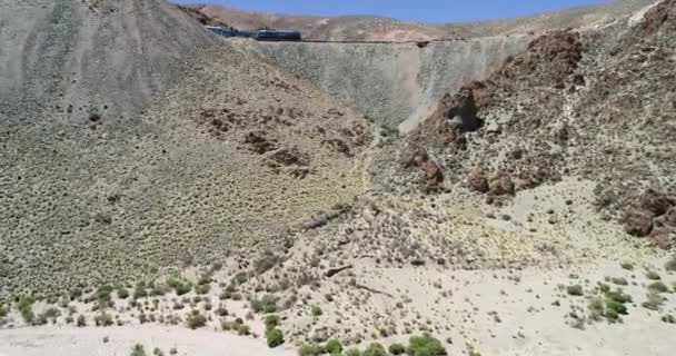 Escena aérea del avión no tripulado del tren conduciendo a través de una montaña desierta. Tren de los couds, tren de las nubes, San Antonio de los Cobres — Vídeo de stock
