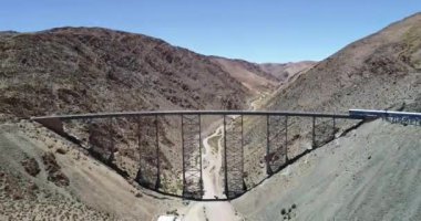 Demir köprü ve istasyonda trenhavadan ön görünümü, insanlar hareket ediyor. Tren bulutları, tren de las nubes, Salta, Arjantin