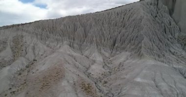 Garip doğrusal doğal çizimler, büyük su erozyonu oluşumları ile beyaz çöl dağ yamacı üzerinde uçan hava drone sahne. Coranzuli, Salta, Arjantin