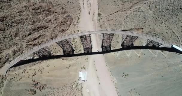 Aéreo de cima para frente vista da ponte de ferro e trem na estação, pessoas se movendo ao redor. Trem das nuvens, tren de las nubes, Salta, Argentina — Vídeo de Stock