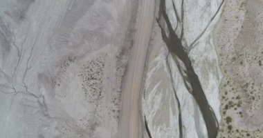 Zalim kurumuş nehirler, yol kenarları, soyut dokular ve şablonlar ile çölleşmiş bir vadi boyunca uçan hava manzarası. Coranzuli, Salta, Argentima