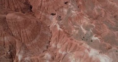 Kırmızı aşınmış kuru dağlık manzaranın yukarıdan ön görünümüne havadan. Kırmızı, turuncu ve beyaz katmanlı renklerle kuru vadiyi keşfetmek. Mars vadisi, Valle de Marte, Cusi Cusi, Jujuy