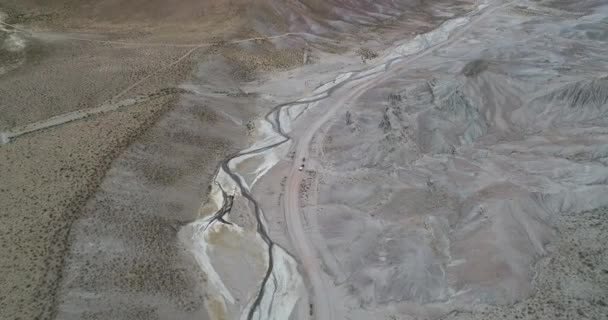 Aérea que muestra valle desértico con ríos secos meandricos. Volando hacia 4x4 con caravana. Coranzuli, Salta, Argentina — Vídeos de Stock