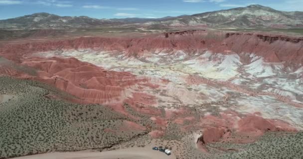 Cena de drones aéreos voando acima de caravanas 4x4 com caravana em direção a montanhas de camada colorida. Vale de Marte, Valle de Marte, Cusi Cusi — Vídeo de Stock