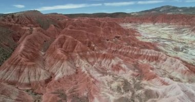 Kırmızı aşınmış kuru dağlık arazi üzerinde uçan hava. Kırmızı, turuncu ve beyaz katmanlı renklerile kuru vadi arka plan. Mars vadisi, Valle de Marte, Cusi Cusi, Jujuy, Arjantin