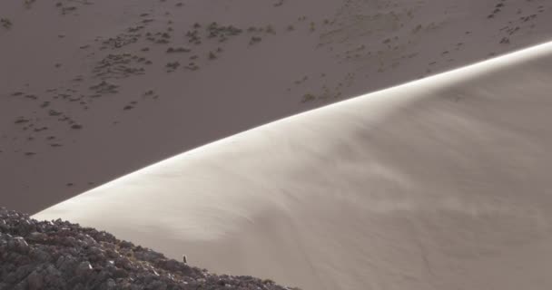 Большая дюна с ветром, дующим песок над поверхностью на закате, детали вершины дюны. Уанкарские дюны, Абра-Пампа, Жужуй, Аргентина — стоковое видео