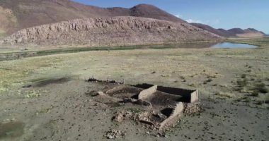 Çölkırsalında vaha ortasında harap taş evin havadan drone sahne. Huancar tepeleri, Abra Pampa, Jujuy, Arjantin