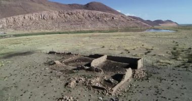 Çöldağ kırsalında vaha ortasında harap taş evin havadan drone sahne. Huancar tepeleri, Abra Pampa, Jujuy, Arjantin
