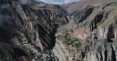 Iruya üzerinde uçan hava, gizli kasaba, dik dar vadi de ahşap ve arka planda kuru renkli tepeler çevrili. Touristic town at Salta, Arjantin