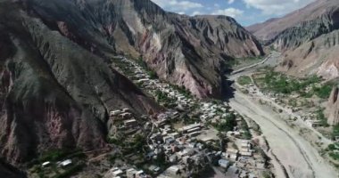 Bulutların, ormanların ve arka planda kuru renkli tepelerin çevrelenmiş dik dar vadisinde, gizli kasaba, Iruya üzerinde uçan hava. Touristic town at Salta, Arjantin