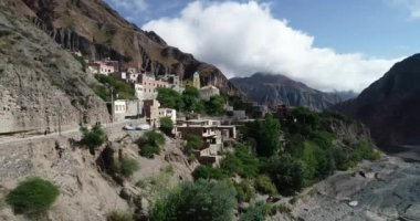 Bulutların, ormanların ve arka planda kuru renkli tepelerin çevrelenmiş dik dar vadisinde, gizli kasaba, Iruya üzerinde uçan hava. Touristic town at Salta, Arjantin