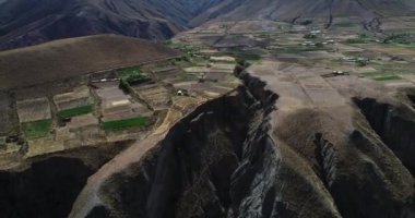 Dağ yamaçlarında ekinler ile küçük çiftlikleri üzerinde uçan hava yüksek derin uçurum ve vadi keşfetmek. Ekim için eski geleneksel sistem. Pueblo Viejo, Salta, Arjantin