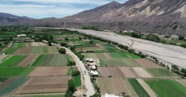 Çölmanzara nehir vadisinde küçük yerel tarım havadan drone sahne. Yeşil vadi kuru çok renkli dağ zinciri ile çevrilidir. Paleta del Pintor, Maimara, Jujuy, Arjantin