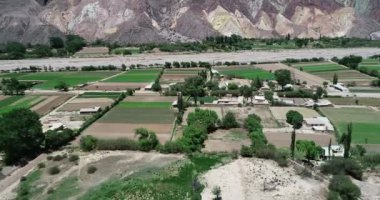 Çölmanzara nehir vadisinde küçük yerel tarım havadan drone sahne. Arka planda çok renkli kuru dağ zinciri. Paleta del Pintor, Maimara, Jujuy, Arjantin