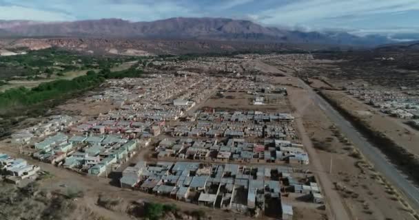 Escena aérea superior de drones de barrio de casas con mismo diseño arquitectónico. Montañas secas al fondo. Humahuaca, Jujuy, Argentina — Vídeos de Stock