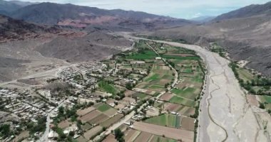 Çölmanzara nehir vadisinde küçük yerel tarım havadan drone sahne. Yeşil ızgara vadi kuru çok renkli dağ zinciri ile çevrili. Paleta del Pintor, Maimara, Jujuy, Arjantin