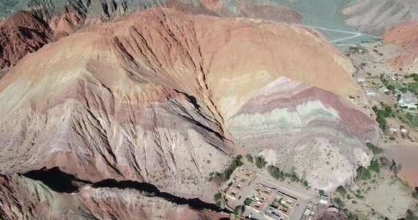 Antena Drone sceny podróży w kierunku Colorfull suche góry pokazano szczegółowo piaskowca. Siedem kolorów gór, Purmamarca miasto, Jujuy, Argentyna. Turystyczne miasto — Wideo stockowe