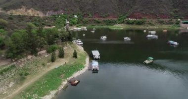 Yatlar, demirleme şamandıraları, iskele, recreative faaliyetleri için kayık ile turistik alanın havadan drone sahne. Kıyı boyunca uçarak altyapıyı gösteriyor. Cabra Corral Barajı, Salta turistik alan, Arjantin