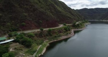 Sahil ve dağ manzara yol boyunca göl üzerinde uçan hava drone sahne. Cabra Corral Barajı, Salta turistik alan, Arjantin