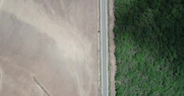 Escena aérea de drones de paisaje deforestados con fines agrícolas.Campo estéril y parque natural en el otro lado de la carretera. Naturaleza versus industria — Vídeos de Stock