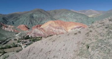 Hava drone sahne renkli kuru dağlar ve küçük köy keşfetmek. Purmamarca torusitic şehrinin panoramik manzarası, Jujuy Province, Arjantin