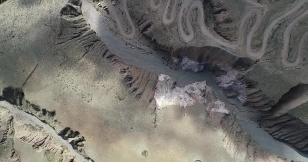 Top antenne scène ontdekken onverharde weg met serpentine vorm op steile berghelling. Iruya, Salta, Argentinië — Stockvideo