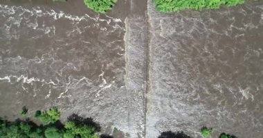 Su basmış köprünün hava manzarası, inşaatın üzerinden geçen kahverengi çamurlu su. Köprü ve bitkisel hayata girmiş sahil manzarası. Mina clavero, traslasierra, cordoba Argentina