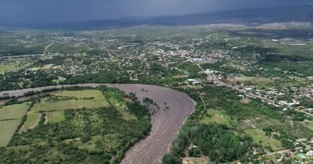 Scena dronów lotniczych rosnącej rzeki, zalewających obszary wiejskie i miejskie Mina Clavero, Traslasierra, Cordoba, argentina — Wideo stockowe