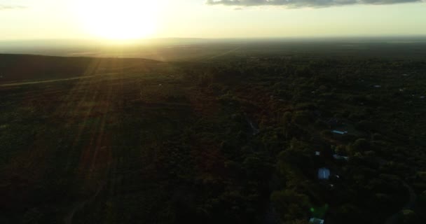 San Javier, Cordoba, Arjantin 'deki ağaçlık bir arazinin üzerinde turuncu günbatımının hava aracı görüntüsü — Stok video