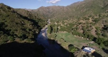 Hava, temiz kayalık nehir vadisi boyunca dağ zincirinin panoramik manzarasına doğru ilerliyor. Vahşi orman manzarası. Rio grande, Nogoli, San Luis, Arjantin