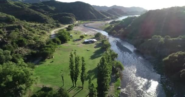 Vista panorámica aérea que viaja a lo largo del valle del río limpio hacia el lago en el paisaje forestal salvaje al atardecer. Volumen de luz. Rio grande, Nogoli, San Luis, Argentina — Vídeos de Stock