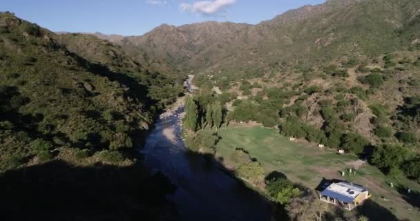 Viagem aérea ao longo do vale do rio rochoso limpo em direção à vista panorâmica da cadeia montanhosa. Paisagem florestal selvagem. Rio grande, Nogoli, San Luis, Argentina — Vídeo de Stock