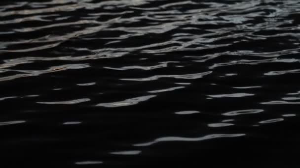 Langzame beweging van water rimpelt bij zonsondergang. Abstracte scène van contrast kleuren beweging, zwart blauw goud en zilver. Trapiche, San Luis, Argentinië — Stockvideo