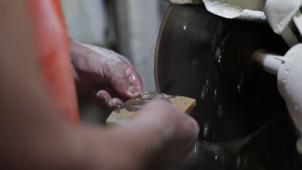 Zeitlupenaufnahme von Menschen, die mit Halbedelsteinen arbeiten. Zwiebelfelsen schneiden, um mit Schneidescheibe und Wasser Schmuck zu erschaffen. la toma, san luis, argentina — Stockvideo