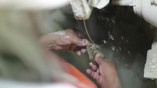 Slow motion shot van de mens beeldhouwwerk met halfedelsteen. Close-up van het snijden van onix rots om sieraden te maken met snijschijf en water. La Toma, San Luis, Argentinië — Stockvideo