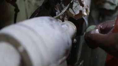 Yarı değerli yeşil küreyi şekillendiren adamın yavaş çekim görüntüsü. Kayaları disk ve suyla cilalayan ellere yakın durun. El işi dekorasyonu. La Toma, San Luis, Arjantin
