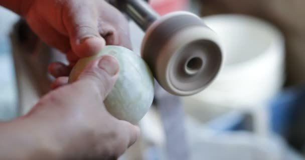 Slow motion shot van de mens beeldhouwen semi kostbare groene bol. Close-up van handen polijsten rots met schijf. Handwerkdecoratie. La Toma, San Luis, Argentinië — Stockvideo