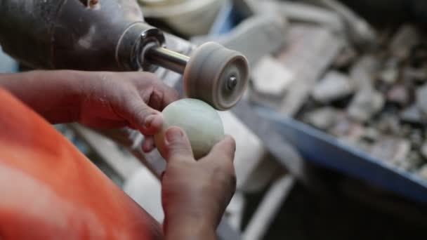 Fotografía en cámara lenta del hombre esculpiendo una esfera verde semipreciosa. Primer plano de manos puliendo roca con disco. Decoración artesanal. La Toma, San Luis, Argentina — Vídeo de stock