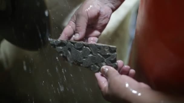 Lassan mozgó felvétel egy emberről, aki féldrágakővel dolgozik. Közelről kéz szeletelő stromatolit kő kövület létrehozása ékszerek vágás lemez és víz. La Toma, San Luis, Argentína — Stock videók