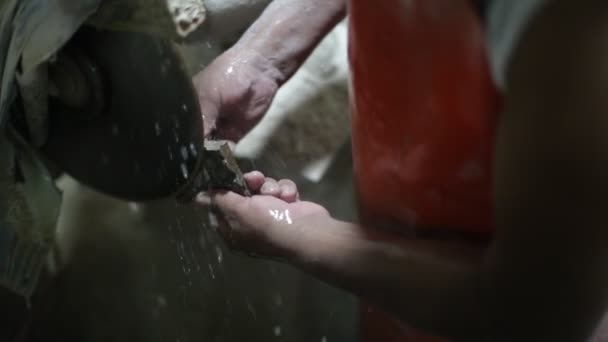 Yarı değerli taşla çalışan bir adamın yavaş çekim görüntüsü. Stromatolit kaya fosilini kesip disk ve su keserek mücevher yaratmak için ellerinizi kapatın. La Toma, San Luis, Arjantin — Stok video