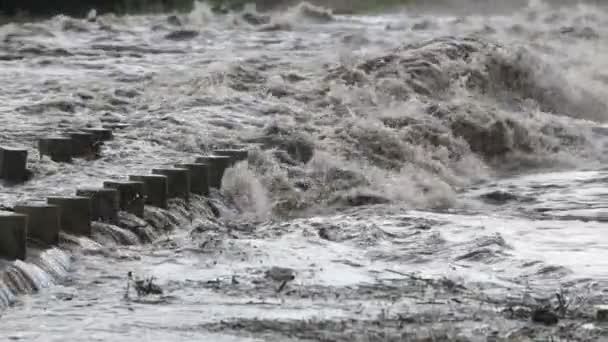 Zeitlupe der überfluteten Brücke. Detail des Geländers, während starke turbulente braune Fluss über die Konstruktion führt. Brunch, Rush erscheinen in der Strömung des Flusses. Hochwasser in mina clavero, cordoba, argentina — Stockvideo