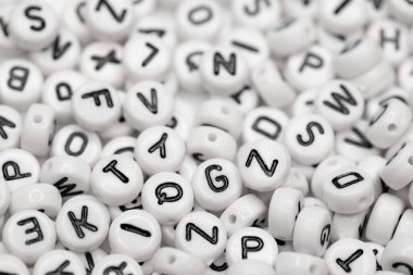 Siyah harfli beyaz plastik boncuklar. Makro atış. Seçici odak.